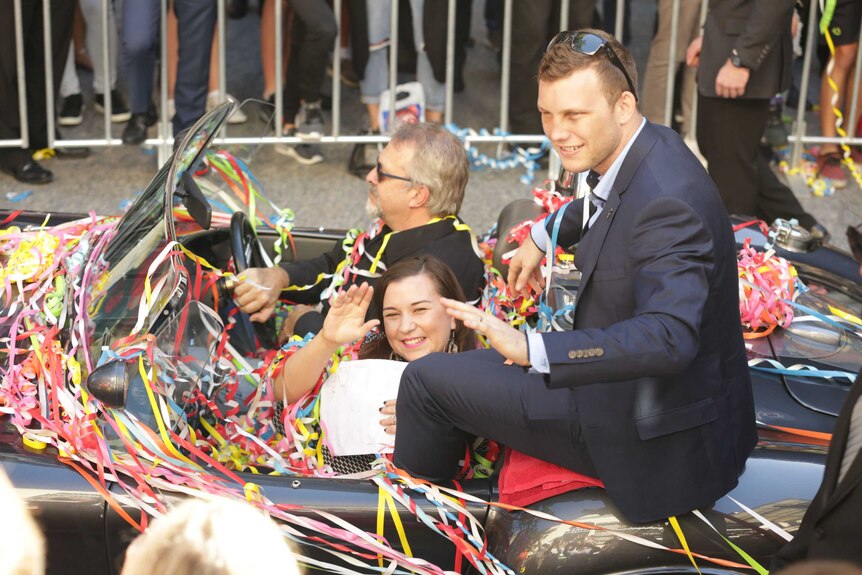 Jeff Horn and his wife Jo wave from the car at Brisbane ticker tape parade