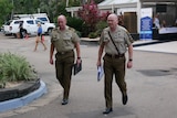 Two high-ranking soldiers walking along a driveway in a carpark