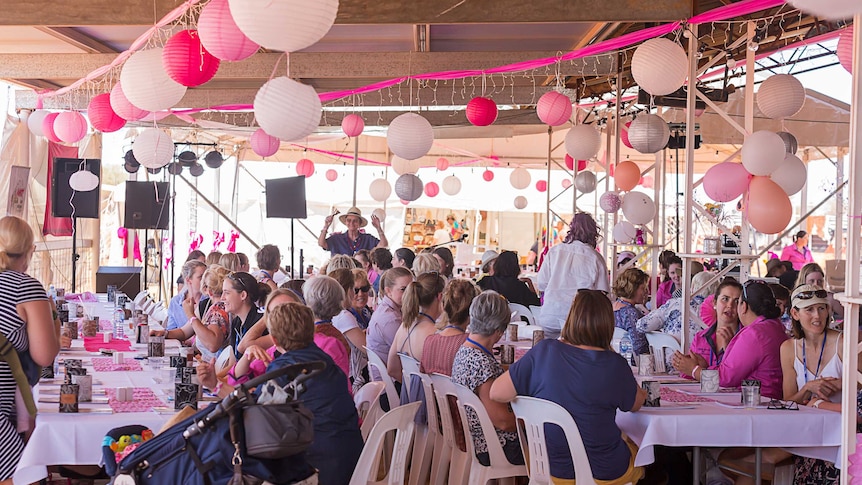 Cathy Hunt presenting at Channel Country Ladies Day under a marquee full of women seated at tables.