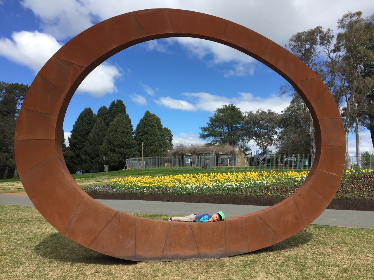 A child lies on a giant ring at Floriade in Canberra.