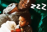Man sleeping beside awake child