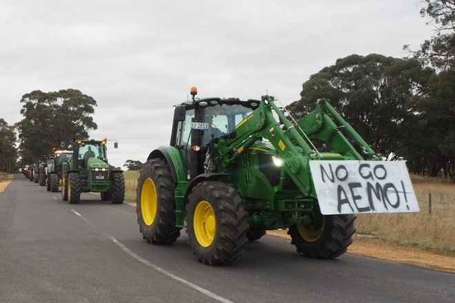 A convoy of tractors with 'No Go AEMO' signs