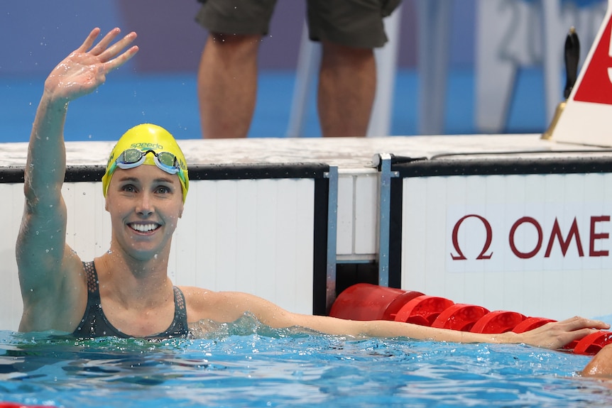Female swimmer waving to the crowd after winning gold at the Olympics  