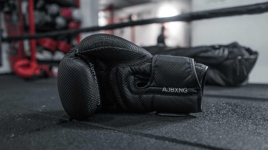 Boxing gloves on the floor of a gym.