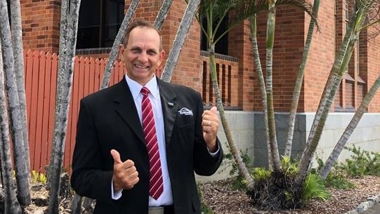 Tony Williams grins and holds his thumbs-up in front of the Rockhampton Council building