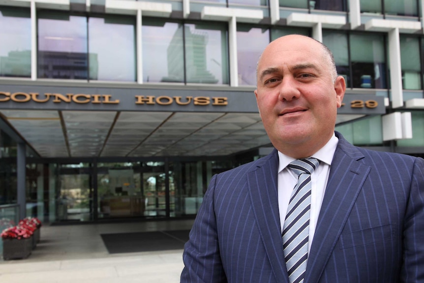 Deputy Lord Mayor James Limnios wearing a striped suit in front of Council House.