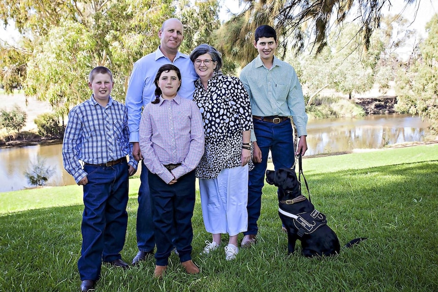 David and Heather Reid, their three children and the service dog Maverick.