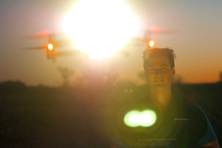 Man stands between a drone and the sun