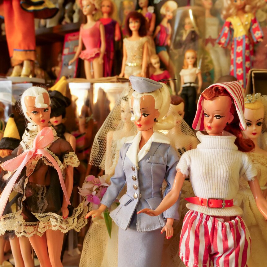 A room of vintage Barbie dolls on stands