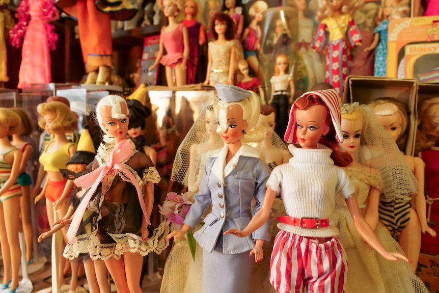 A room of vintage Barbie dolls on stands