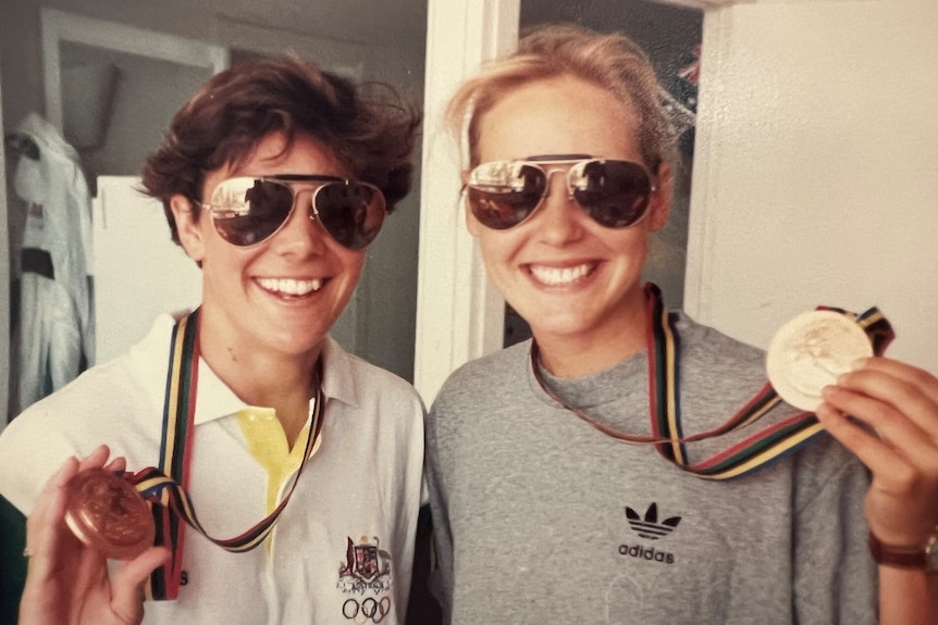 two female athletes holding their olympic medals