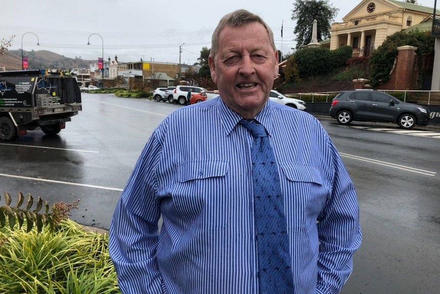 Smiling man wearing blue and white pinstripe shirt, blue tie