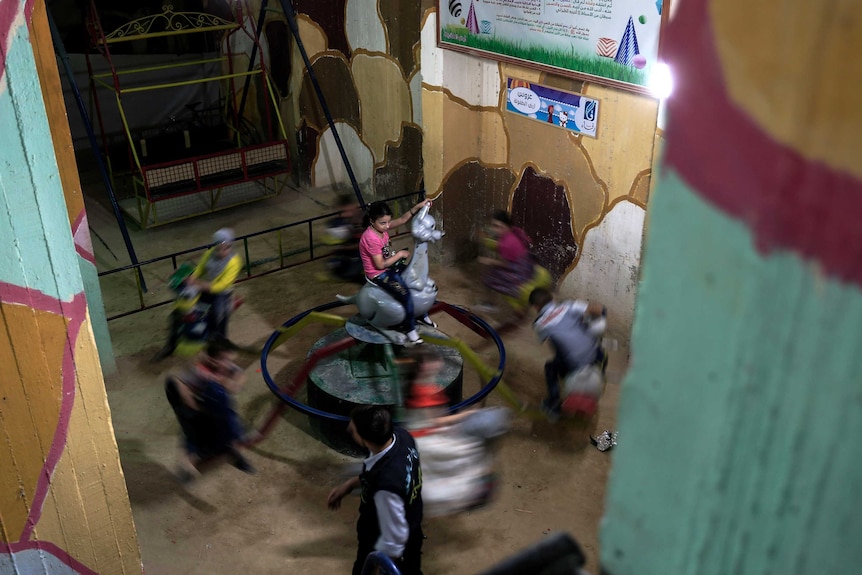 Syrian children play in an underground playground built to protect them from shelling in the rebel-held town of Arbin.