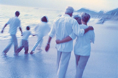 multigenerational family walking on the beach