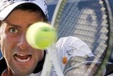 Novak Djokovic hits a return on his way to a tough five-set win