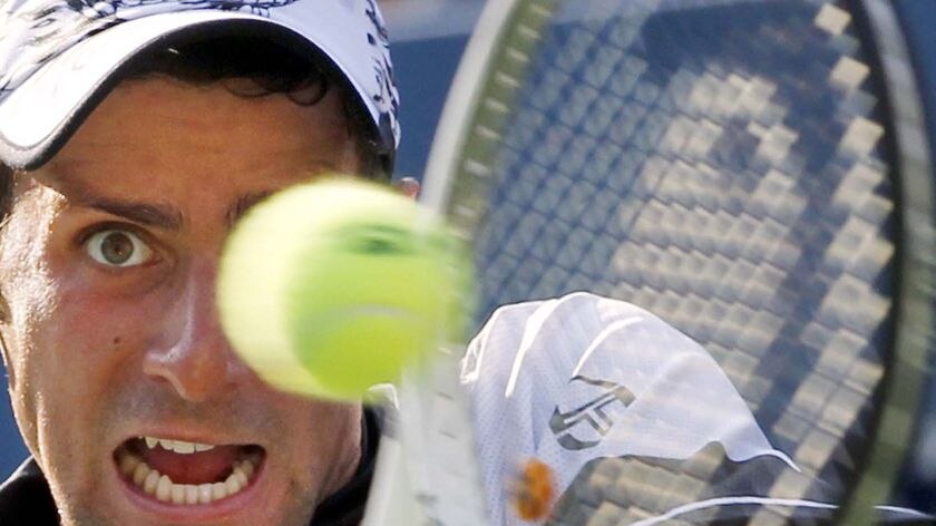 Novak Djokovic hits a return on his way to a tough five-set win