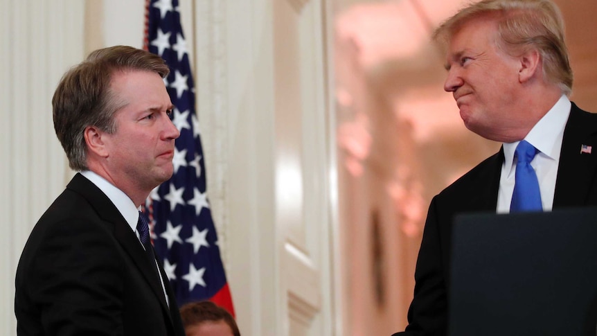 Brett Kavanaugh shakes hands with Donald Trump