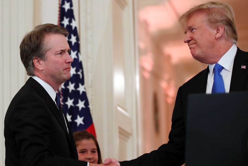 Brett Kavanaugh shakes hands with Donald Trump