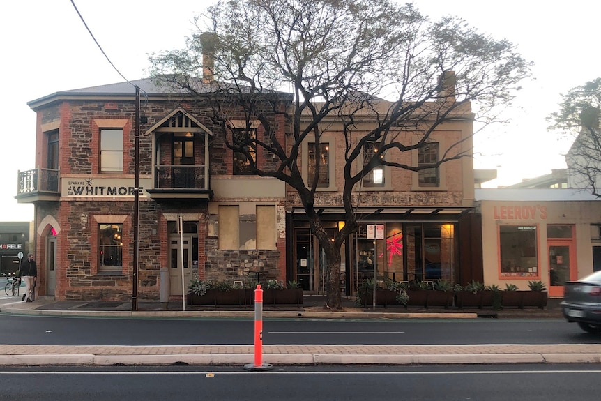 An old pub with a tree and a road in front of it