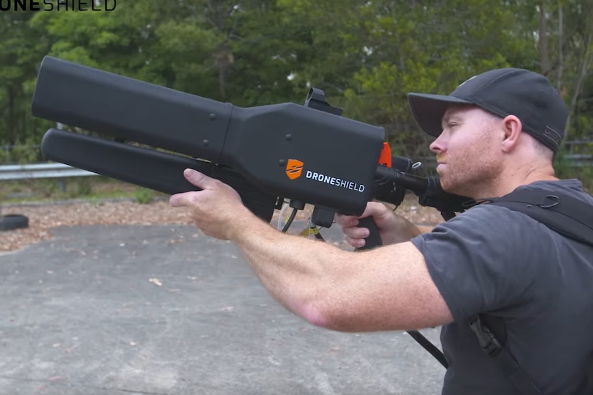 A man uses the DroneShield 'DroneGun' to take down a distant drone.