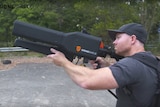 A man uses the DroneShield 'DroneGun' to take down a distant drone.