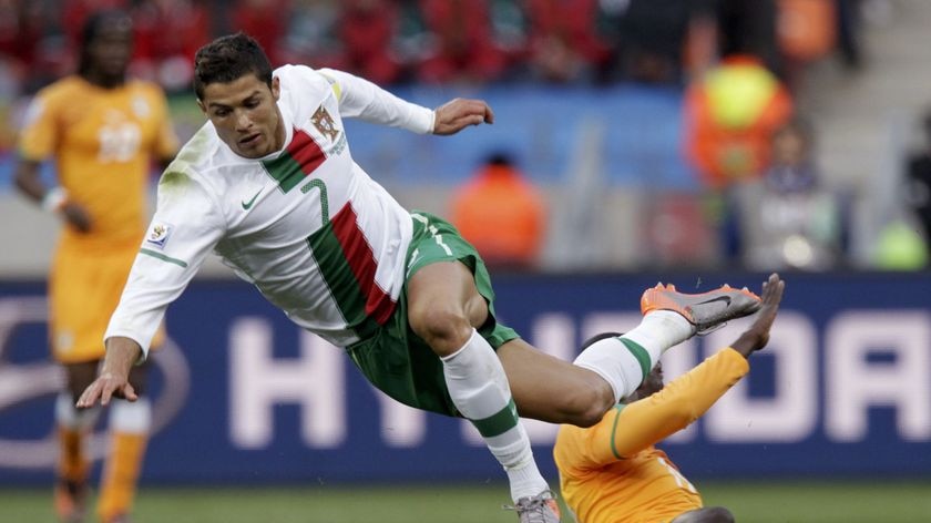 Portugal's Cristiano Ronaldo flies to the turf after a challenge from Ivory Coast's Yaya Toure.