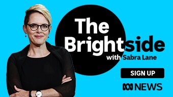 Sabra Lane stands with her arms folded in front of a sign-up promo for The Brightside