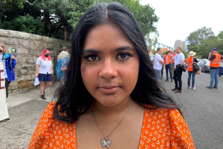 An unsmiling girl stares toward the camera