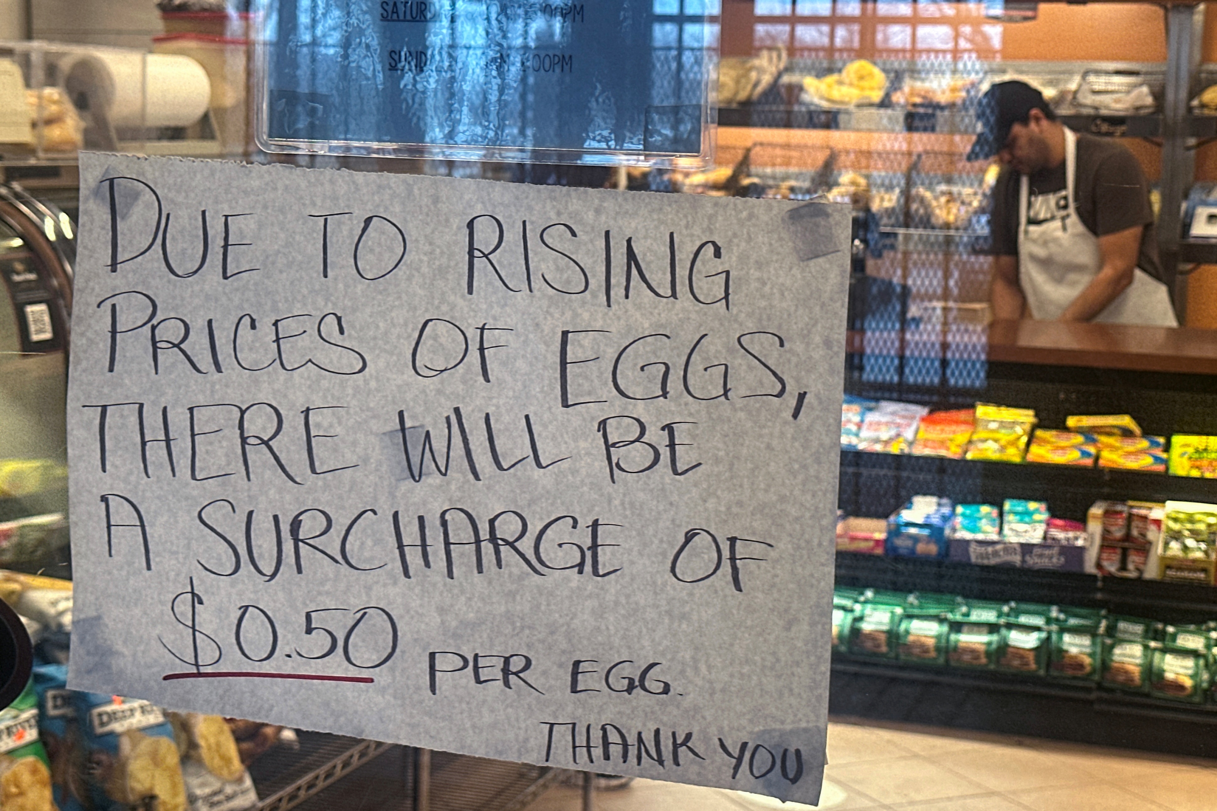 A sign alerts customers to an egg surcharge. 