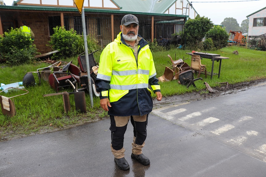 a man wearing a cap standing out the front 