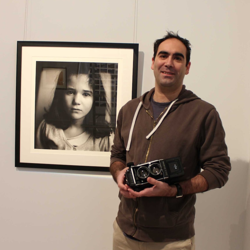 Finalist Ben Robson stands next to his photograph