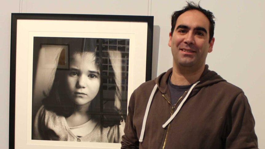 Finalist Ben Robson stands next to his photograph