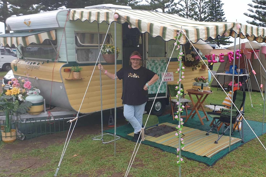 Vintage van decorated in yellow and green with a classic striped awning and outdoor table setting. 