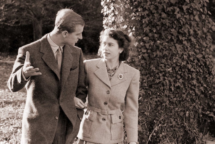 A young Princess Elizabeth and The Duke of Edinburgh walk together.