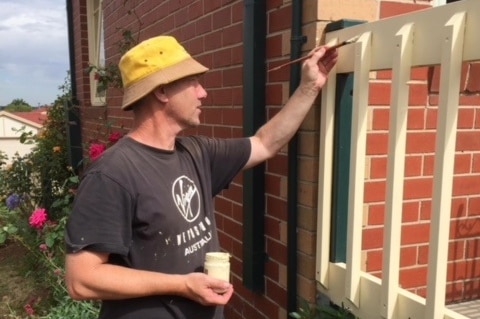 Brad May paints his fence at home