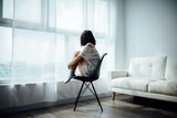 An image of a young person sitting alone in an apartment.