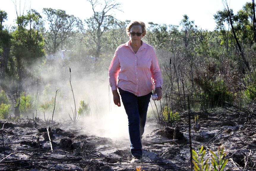 Woman walks through dust.