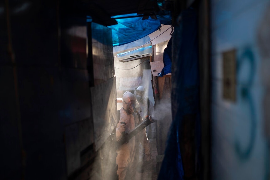 Volunteers wearing protective suits disinfect an alleyway in Brazil.