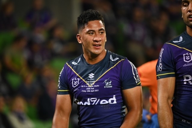 Dean Ieremia wears a purple Melbourne Storm jersey as he walks on the field during a match.