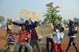 Demonstrators pose with placards reading "Michel must leave" and "Djotodia must leave, we want peace".