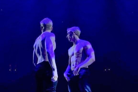 Two shirtless men on stage