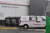 A police van near a line of charity bins