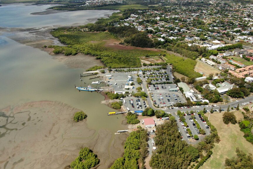Aerial shot of Toondah Harbour showing the carpark, homes, and the sweep of the coastline.