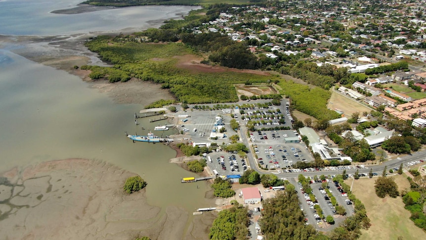Aerial shot of Toondah Harbour showing the carpark, homes, and the sweep of the coastline.