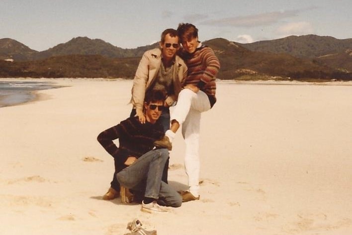 Three men pose for a photo