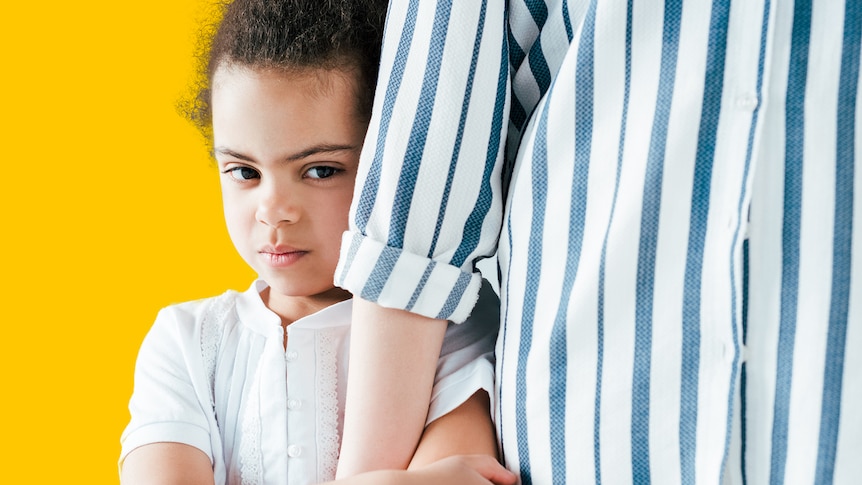 A child with dark curly hair is seen holding the arm of an adult wearing a blue and white striped top, against yellow background