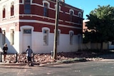 Locals look at rubble from the Commercial Hotel in Boulder
