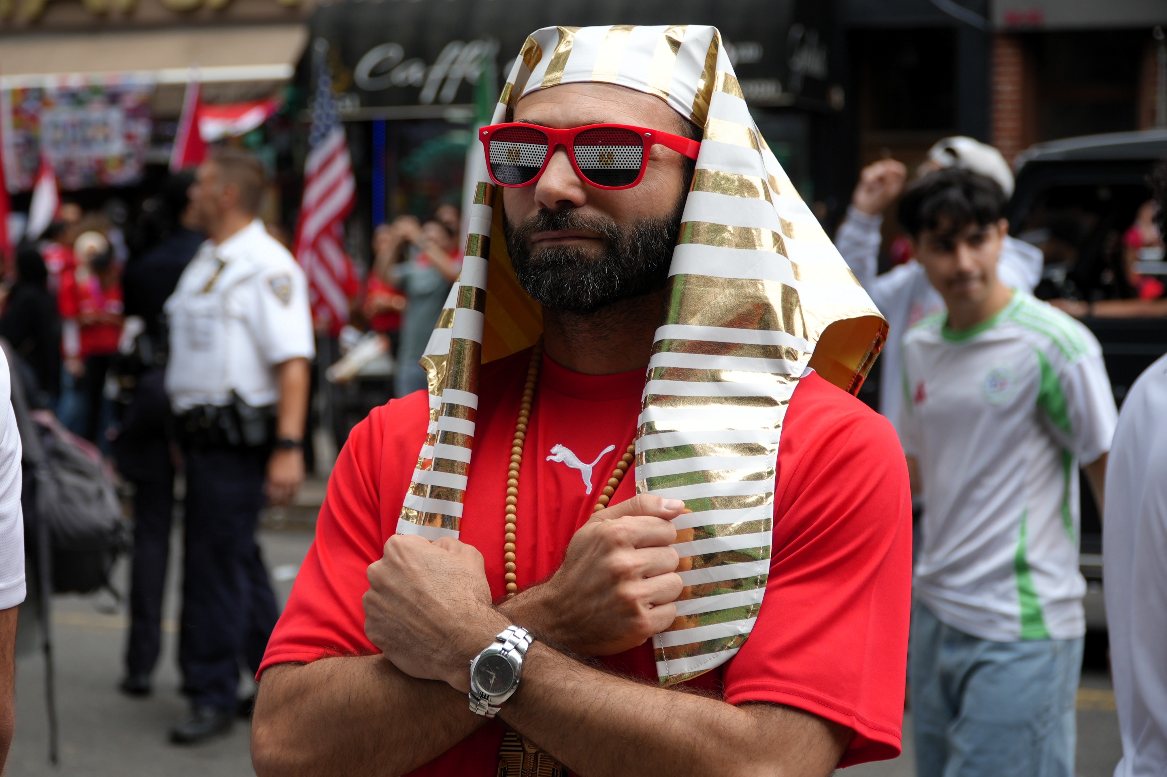 A man with a Pharoah headdress and Egypt sunglasses poses