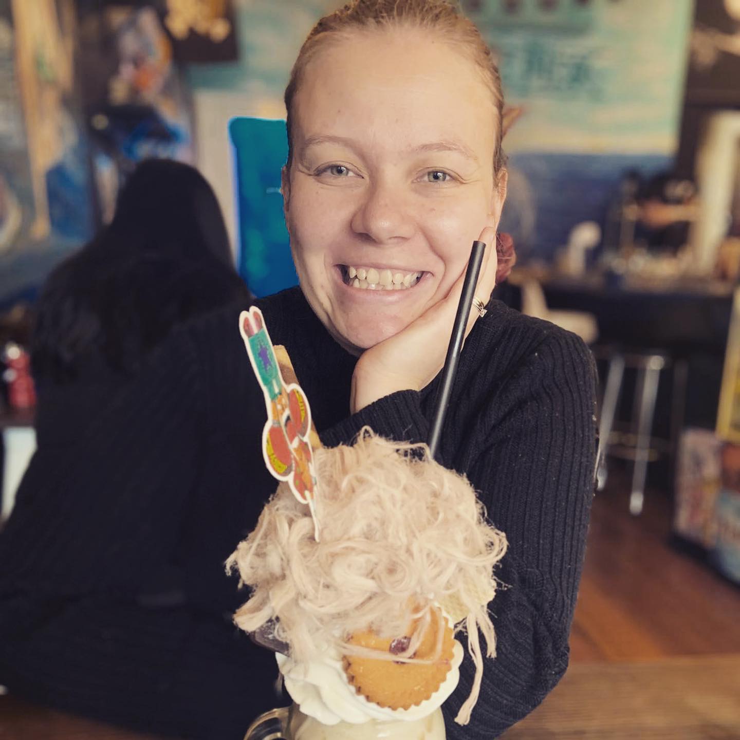 Silvi Vann-Wall smiles into the camera while sitting at a cafe with a turkish-fairy-floss covered shake.