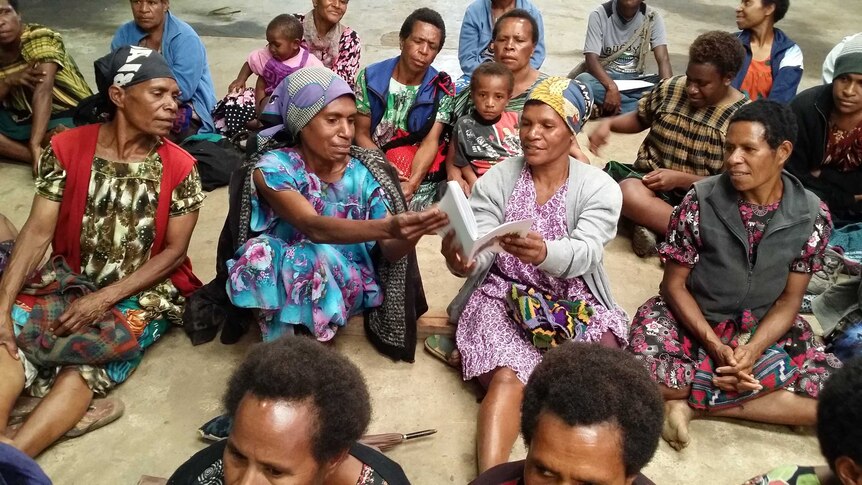 Bilum weavers looking at pictures of their work